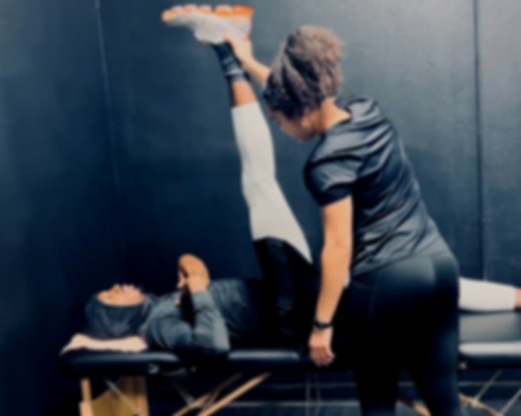 Minah performing hands on assisted stretch therapy in the studio